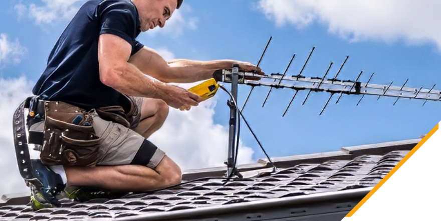 An electrician installing an antenna cable on the roof