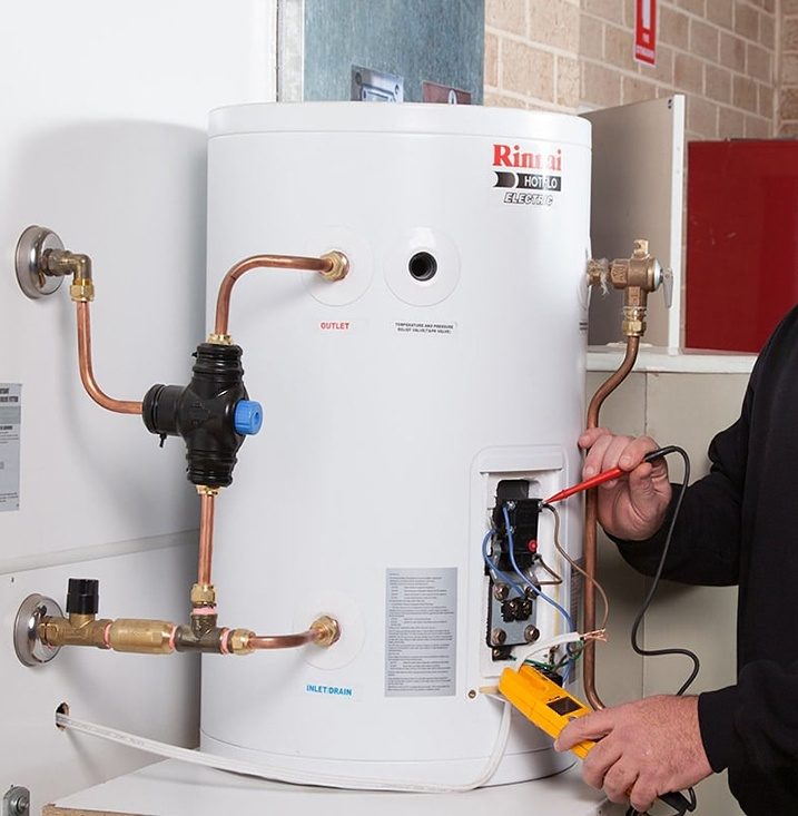 An electrician working on a hot water system in Sydney
